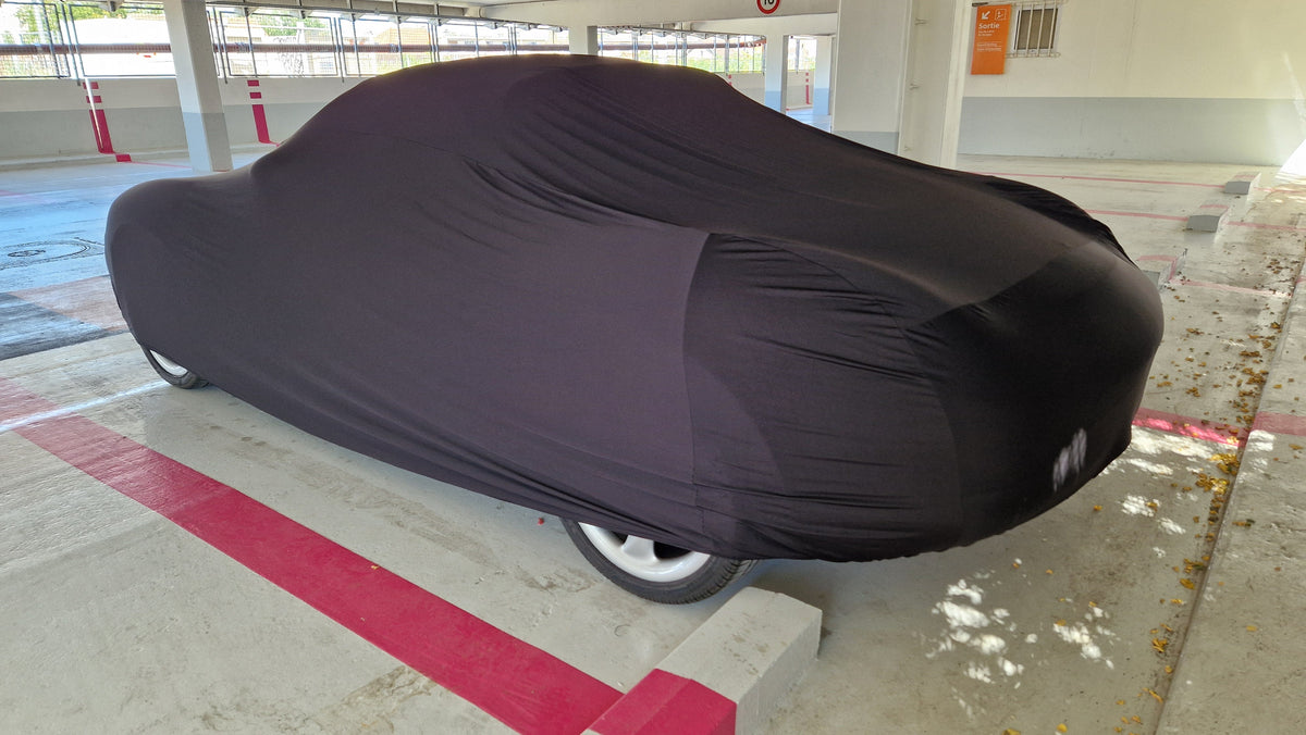 Black Stretch™ indoor car cover in a garage
