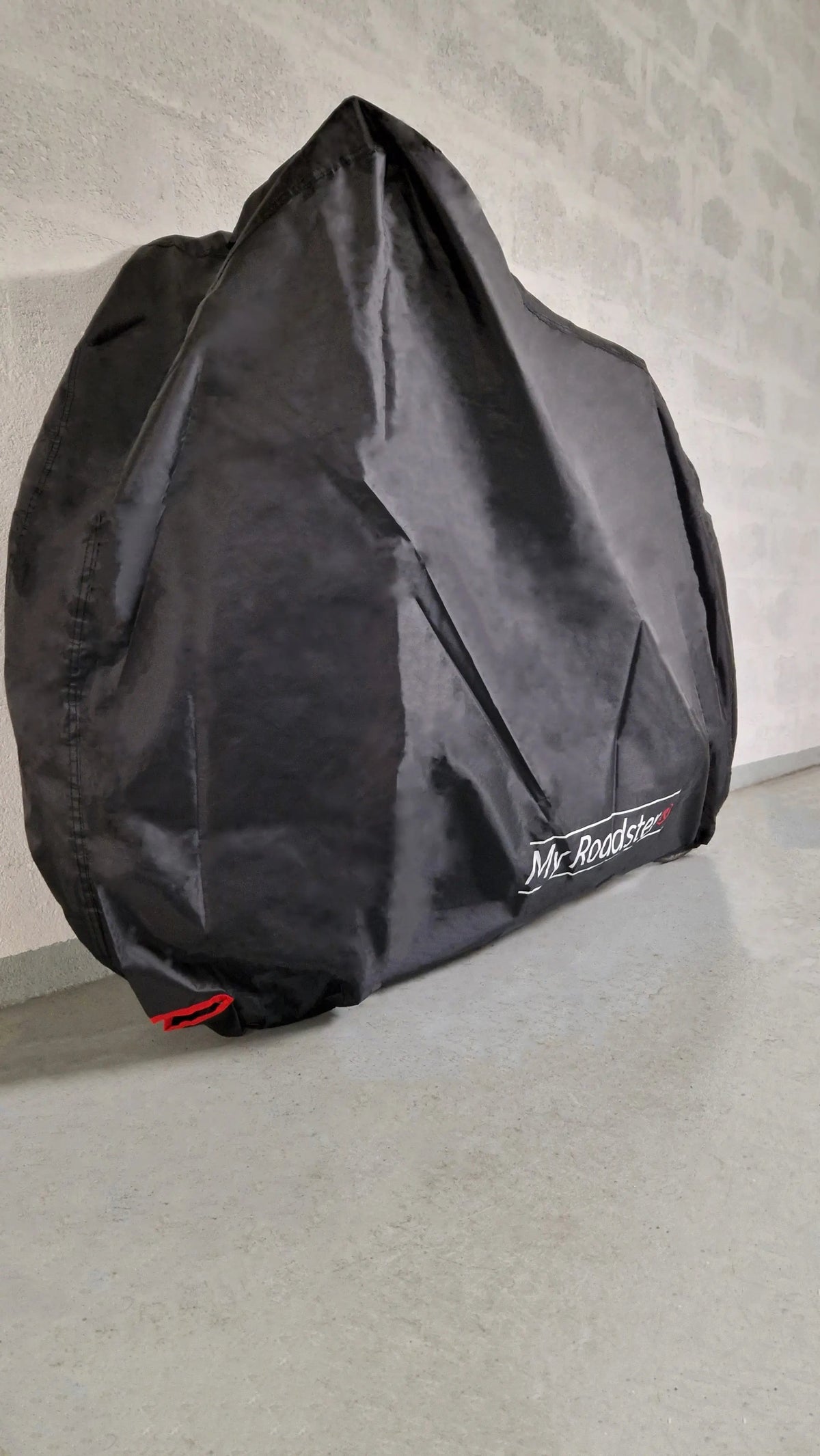Bike cover with elasticated hem and wind strap